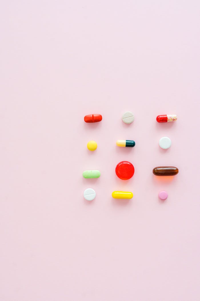 why-choose-us-02 Vibrant assortment of pills and capsules arranged on a soft pink background.
